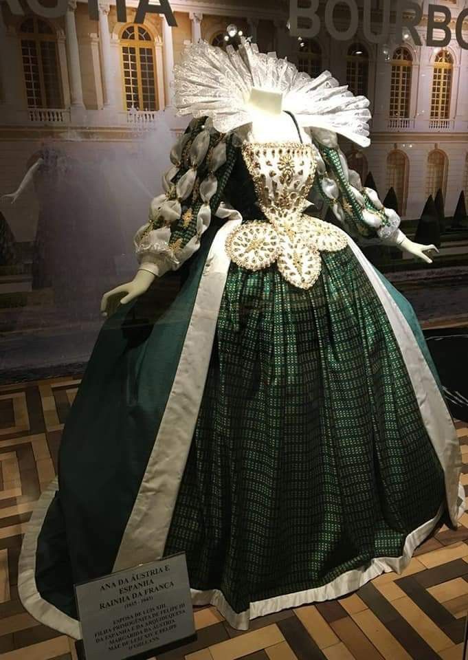 Emerald court costume with a structured cape and ornate collar.